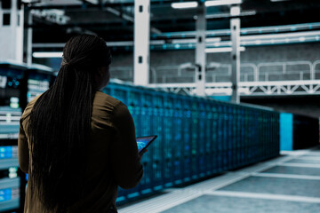 Engineer uses AI assistant to implement security measures, fortifying data center defenses against cyber threats. Server hub worker uses artificial intelligence to detect threats, defending systems