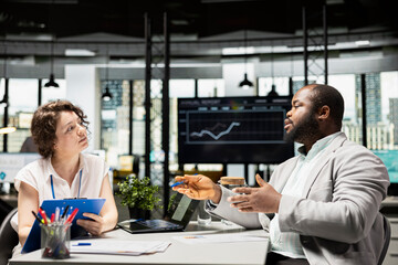 Female HR professional interviewing black candidate for a business vacancy, looking for the right qualifications to fill this job position. Workforce recruitment process in corporate office.