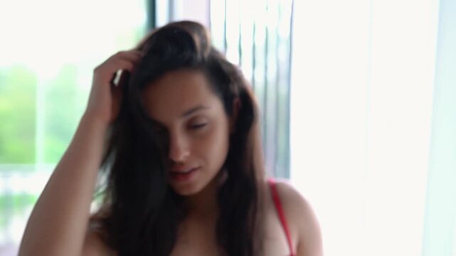 Young lady in underwear looking at camera posing and moving near window