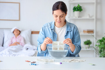 Mother dipping mustard plaster into water for her ill daughter in bedroom