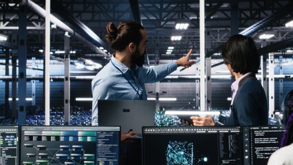 Team of engineers doing brainstorming in server room using AI to review infrastructure diagnostics. Teamworking IT colleagues in data center analyzing data using artificial intelligence, camera A