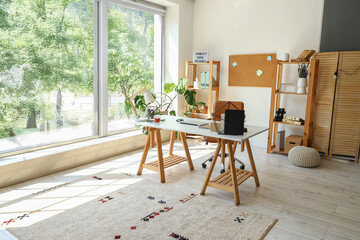 Interior of light office with workplace and shelving units