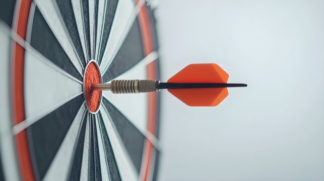 A dart hitting the bullseye on a clean white background. Perfect shot for a target or business goal concept. Accuracy and success.