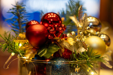Festive Christmas still life with red and gold ornaments, pine branches and warm fairy lights in a glass bowl, cozy holiday home decor concept with bokeh background, winter celebration, New Year