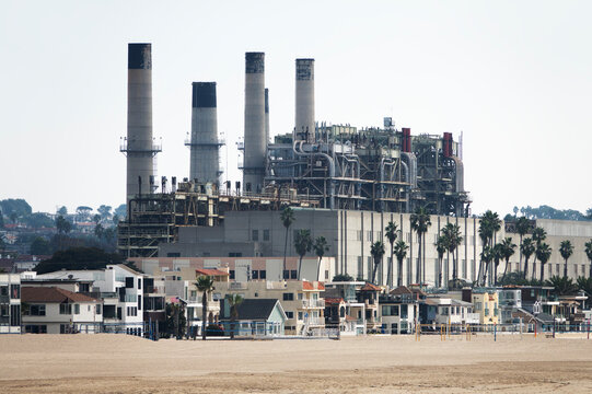 View of Hermosa Beach homes and industrial power plant smokestacks in the South Bay area of Los Angeles County California.  