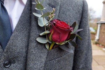 Groom boutonniere pinned on suit lapel close-up