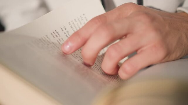 closeup hands tracing text in book, soft warm light, vintage hardcover, careful finger following lines, quiet focused study, subtle page texture and margin notes, slow turning motion, intimate