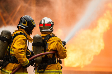 Firefighters using hose to control flames during emergency response