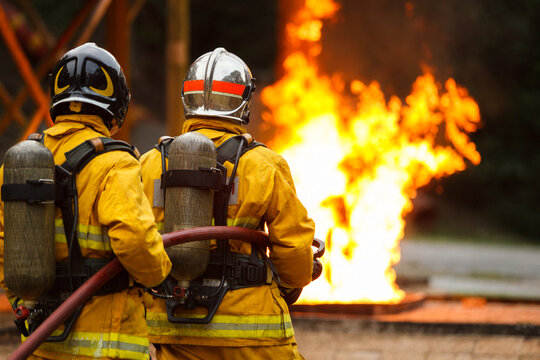 Firefighters using hose to control flames during emergency response