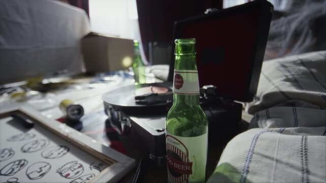 Close up shot of beer bottles and retro record player set on floor, people living in abandoned house concept, copy space