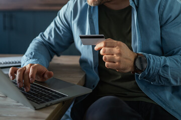 Man making secure online payment using credit card and laptop