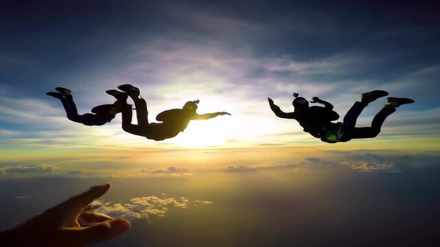 Skydiving silhouettes against a sunset sky filled with clouds, capturing the thrill of the aerial adventure
