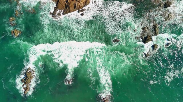 Drone hovering above Atlantic ocean waves near rocky coastline in Ancora, Portugal