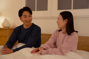 ベッドの上で会話する夫婦