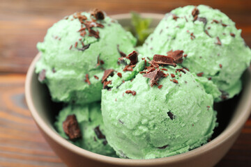 Tasty mint chocolate chip ice cream on wooden table, closeup