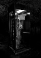 薄暗い心霊スポットの不気味な電話ボックスの中の女の子の幽霊モノクロ
