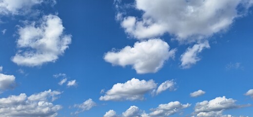 Beautiful blue sky with fluffy white clouds and copy space for background