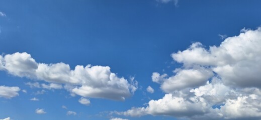 Beautiful blue sky with fluffy white clouds and copy space for background