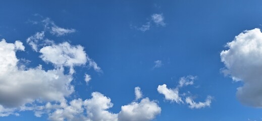 Beautiful blue sky with fluffy white clouds and copy space for background