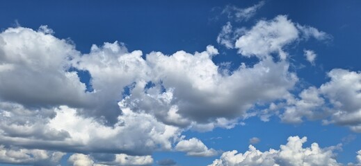 Beautiful blue sky with fluffy white clouds and copy space for background