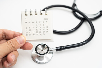 Hand holding desk calendar set to JANUARY 2026. Doctor Appointment Schedule and Annual Health Checkup Reminder. Preventive medicine, healthcare planning, doctor visits, and timely examinations.