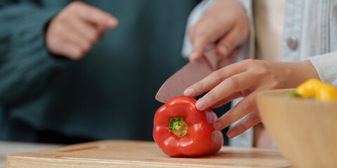Cooking Party: Close-Up of Friends Chopping Red Pepper Together