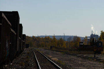 Obraz premium Canada, Quebec, 14 October 2025 : Industrial trains and tracks winding through autumn trees and smokestacks.