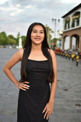 Fototapeta premium Cheerful teenager wearing a black dress looking at the camera