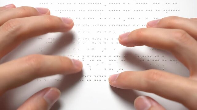 Close-up of Hands Reading Braille Text.