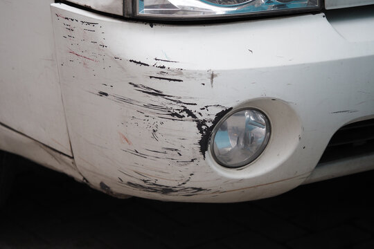 Car with scratches on the front bumper parked in the street