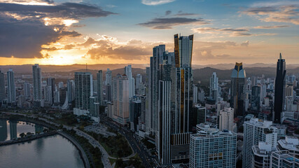 Close aerial view of modern high-rise buildings in Panama City illuminated by warm golden hour sunset light © Anton Gots