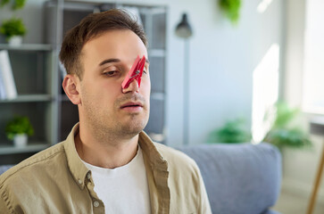 Man with clothespin on his nose symbolizing bad smell, congestion and cold and showing nasal...