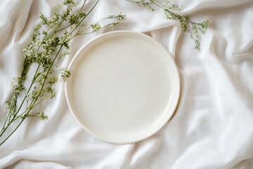 Minimalistic White Plate Surrounded by Fresh Greenery on Linen Fabric