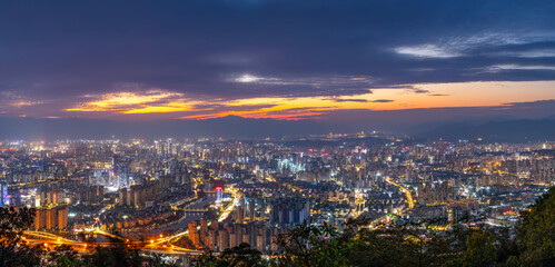 Obraz premium Dusk cityscape with illuminated buildings and twilight sky