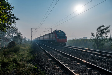 Obraz premium Saffron coloured Vande Bharat Express near Pune India. This is a made in India train set and also known as Train 18.
