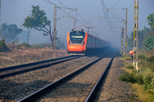 Saffron coloured Vande Bharat Express near Pune India. This is a made in India train set and also known as Train 18.