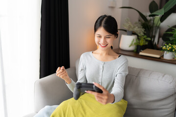 Young Asian woman gamer controller video console playing holding hobby playful Online Video Game...