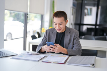 Fototapeta premium Asian Businessman with Smartphone&nbsp;working mobile devices cell telephone technology e-commerce smartphone business professional investor working new start up project