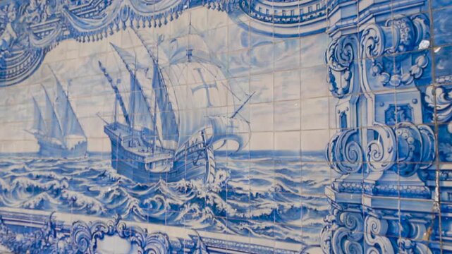 Detailed view of blue portuguese azulejos ceramic tiles on a outside wall at Paco de Arcos. Large wooden historical sailboat art and waves on it with templar crosses and religious details.