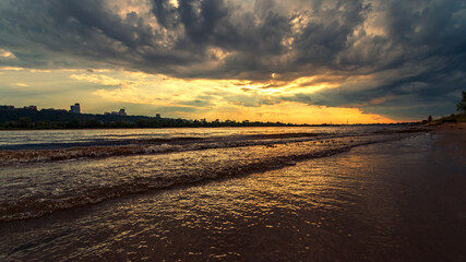 Beautiful summer sunset and colorful sky over the river or lake. Clouds are reflected in the calm water. Beauty in this world
