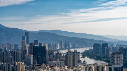 Obraz premium Panoramic View of Urban Skyscrapers with River and Mountains