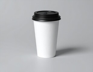 A blank white paper cup with a black lid, on a gray surface