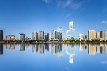 Obraz premium Modern City Skyline with Reflection in Calm Water