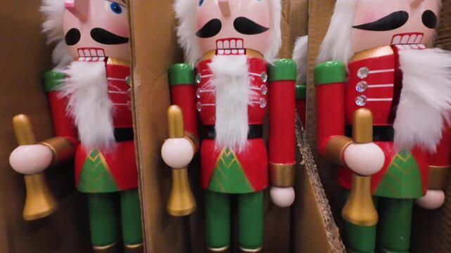 Wooden nutcracker figurines are displayed in a shopping center aisle. These traditional Christmas decorations are ready for purchase during the holiday season.