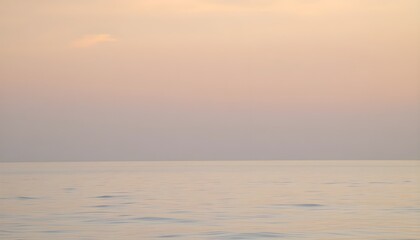 Minimalist seascape with calm water and pastel sunset sky near the horizon. Great for travel, relaxation, meditation themes, backgrounds, and typography overlays.
