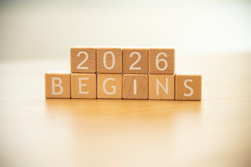 Wooden cube blocks 2026 begins background. Texts and numbers on wooden blocks with copy space. 2026 happy new year idea concept.