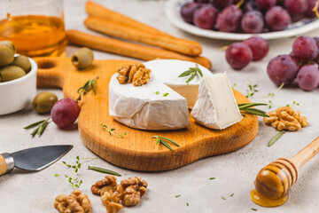 Brie cheese on a board with walnuts and honey