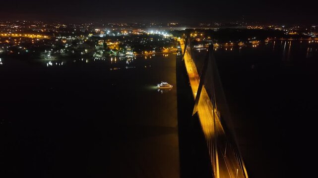 Aerial fly Night View Illuminated San Roque Gonz&aacute;lez Bridge and Catamaran on Paran&aacute; River Argentina