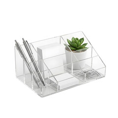 Clear acrylic desk organizer with pens, notes, a plant, and paper clips on transparent background
