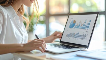 "Person working on laptop with pie and bar charts, analyzing data in bright office with large windows"